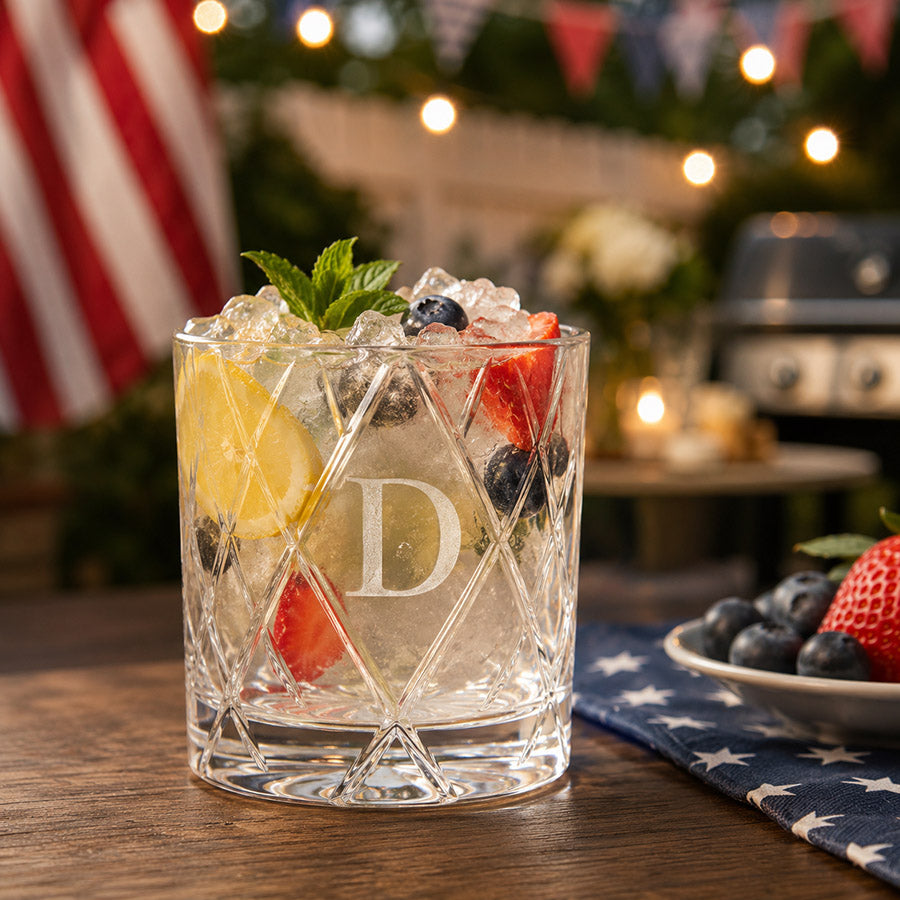 Personalized cut crystal rocks glass with engraved initial D, filled with a patriotic summer cocktail and berries -- lxi-context:4th-of-july