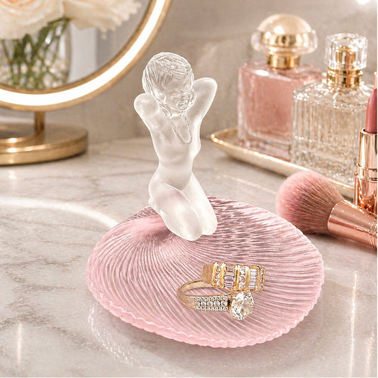 Pink glass jewelry dish with frosted figurine, rings, and vanity display with perfume and makeup accents -- lxi-context:mothers-day