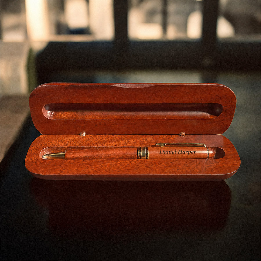 Personalized rosewood pen displayed inside open matching box with Daniel Harper name engraved on the pen
