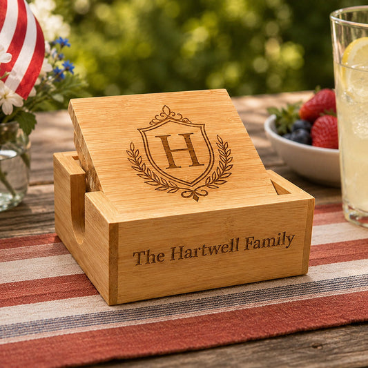 Personalized bamboo coaster set with engraved Hartwell Family crest, shown on a patriotic 4th of July outdoor table -- lxi-context:4th-of-july